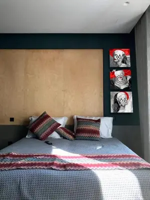 a bed in a bedroom with two pictures on the wall at CentraL44 WoW CasuaL Suite-Ermou view in Athens