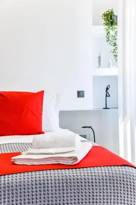 a bed with red and white pillows on it at CentraL44 OMG Casual Suite-Ermou view in Athens