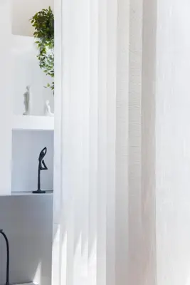 a window with a white curtain next to a chair at CentraL44 OMG Casual Suite-Ermou view in Athens