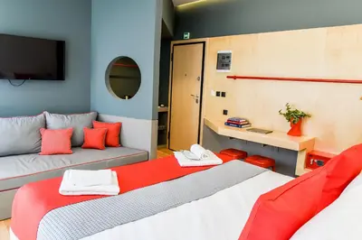 a small room with two beds and a tv at CentraL44 OMG Casual Suite-Ermou view in Athens