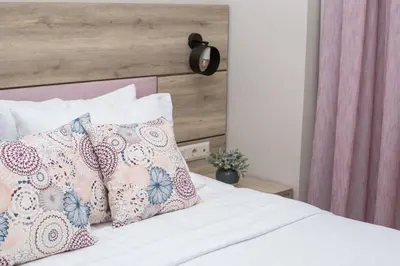 a bed with pink and white pillows on it at Acropolis Vision in Athens