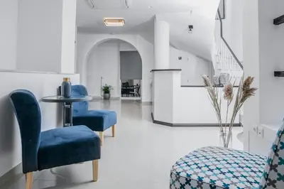a living room with blue chairs and a table at Acropolis Vision in Athens