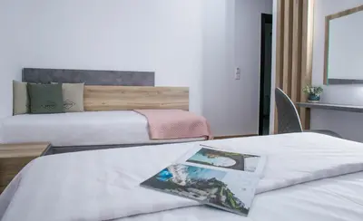 a hotel room with two beds and a magazine at Acropolis Vision in Athens