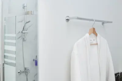 a bathroom with a shower and a white robe at Acropolis Vision in Athens