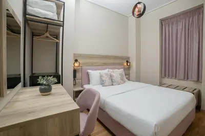 a bedroom with a bed and a table and a desk at Acropolis Vision in Athens