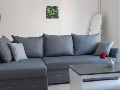 a blue couch in a living room with a table at ΜΕ ΘΕΑ ΤΟ ΛΙΜΑΝΙ in Piraeus