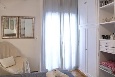 a living room with a chair and a large window at VZ Athens Apartment in Athens