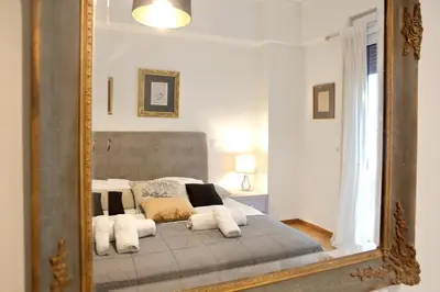 a mirror reflection of a bed in a bedroom at VZ Athens Apartment in Athens