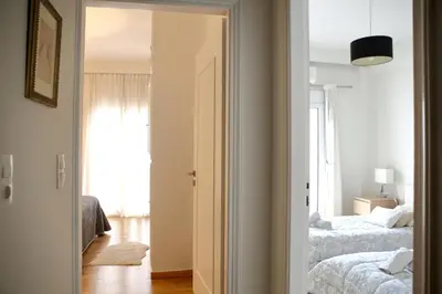 a bedroom with two beds and a door leading into a room at VZ Athens Apartment in Athens