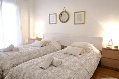 a bedroom with two beds and a mirror on the wall at VZ Athens Apartment in Athens