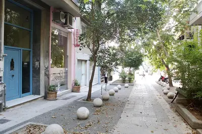 a street with trees and white balls on the sidewalk at VZ Athens Apartment in Athens