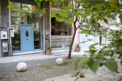 a building with a blue door and a tree at VZ Athens Apartment in Athens