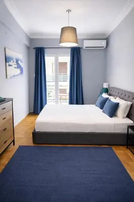 a bedroom with a bed with blue curtains and a blue rug at Comfortable Modern Entire House near the center of Athens-Blue Serenity in Athens