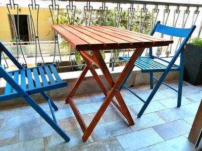 a wooden table and two blue chairs on a patio at Comfortable Modern Entire House near the center of Athens-Blue Serenity in Athens