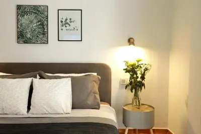 a bedroom with a bed with a vase of flowers on a table at Super Comfrortable Modern Apartment in Kolonaki in Athens
