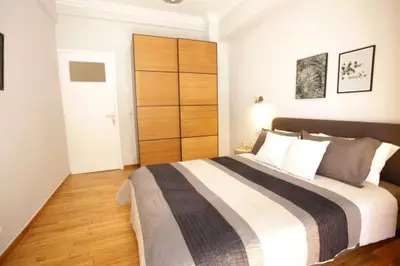 a bedroom with a large bed with a wooden closet at Super Comfrortable Modern Apartment in Kolonaki in Athens