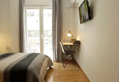 a bedroom with a bed and a desk and a window at Super Comfrortable Modern Apartment in Kolonaki in Athens