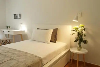 a bedroom with a bed and a vase of flowers on a table at Super Comfrortable Modern Apartment in Kolonaki in Athens