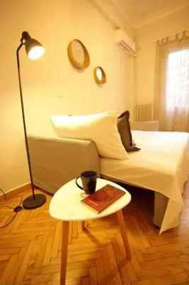 a bedroom with a bed and a table with a book at Super Comfrortable Modern Apartment in Kolonaki in Athens