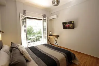 a bedroom with a bed and a sliding glass door at Super Comfrortable Modern Apartment in Kolonaki in Athens