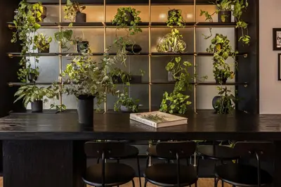 a table with chairs and plants on a wall at The Modernist Athens in Athens