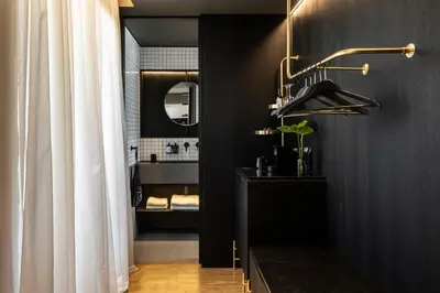 a bathroom with a black wall with a mirror at The Modernist Athens in Athens