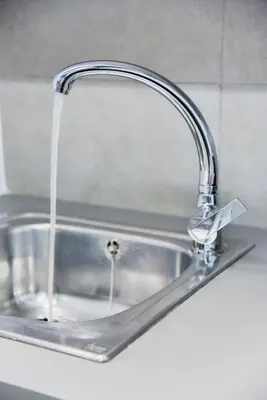 a kitchen sink with water running from a faucet at CentraL44 YoLo Casual Suite- Ermou in Athens