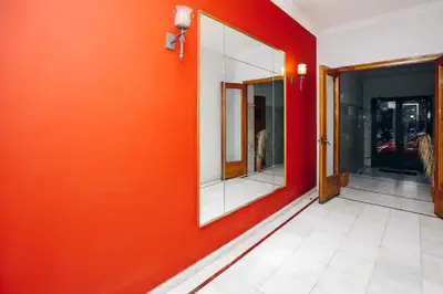 an orange wall with a mirror in a hallway at Omirou “Best Kept Secret” in Athens
