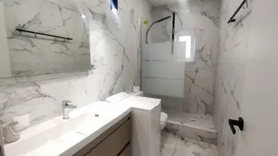a white bathroom with a sink and a toilet at Palio Faliro Deluxe Apartment near the sea in Athens