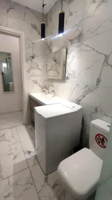 a white bathroom with a toilet and a sink at Palio Faliro Deluxe Apartment near the sea in Athens