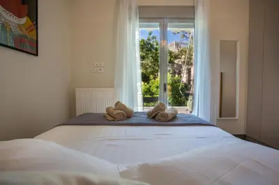 a bedroom with a large bed with a window at Acropolis Slow Living apt under the Parthenon in Athens