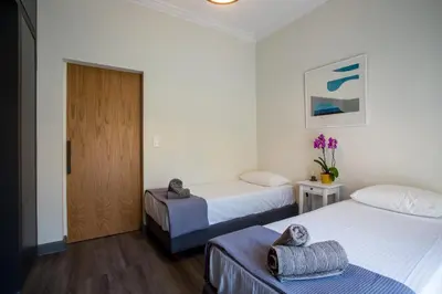 a hotel room with two beds and a door at Acropolis Slow Living apt under the Parthenon in Athens
