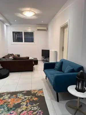 a living room with a blue couch and a tv at Anna's House in Athens