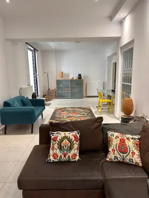 a living room with a brown couch and a blue chair at Anna's House in Athens