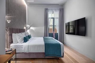 a bedroom with a bed and a television on a wall at Hellenic Vibes Smart Hotel in Athens
