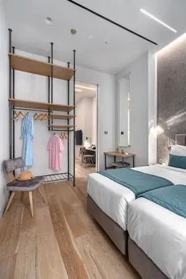 a bedroom with a bed and a chair at Hellenic Vibes Smart Hotel in Athens