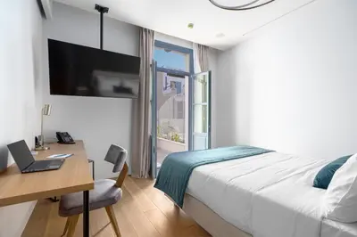 a bedroom with a bed and a desk with a laptop at Hellenic Vibes Smart Hotel in Athens