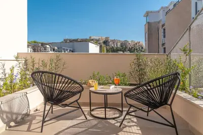 a patio with two chairs and a table on a balcony at Hellenic Vibes Smart Hotel in Athens