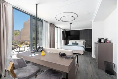 a hotel room with a bed and a desk and chairs at Hellenic Vibes Smart Hotel in Athens
