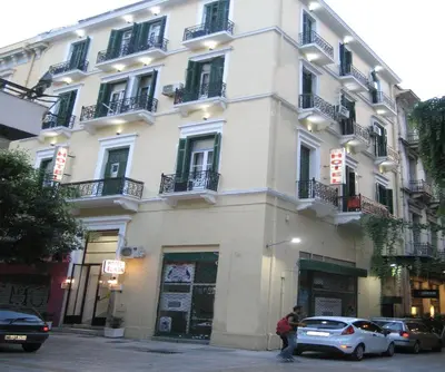 a white building with cars parked in front of it at Elikon in Athens