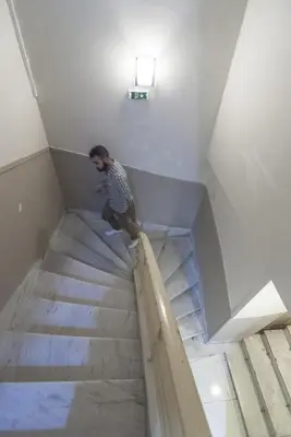 a man is walking down a set of stairs at Elikon in Athens