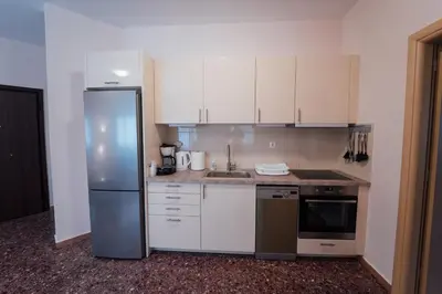 a kitchen with white cabinets and a stainless steel refrigerator at Luxury Apartment in Plaka - Acropolis (Rosemary) in Athens