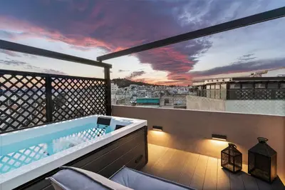 a hot tub on a balcony with a view at ACRON suites & apartments in Athens