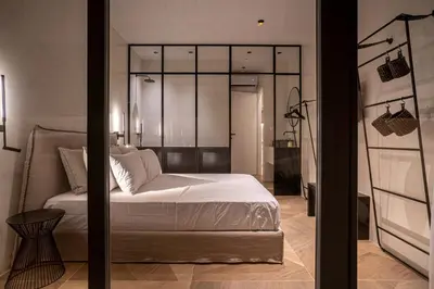 a bedroom with a white bed and a glass wall at ACRON suites & apartments in Athens