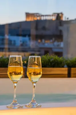 two glasses of white wine sitting on a table at ACRON suites & apartments in Athens