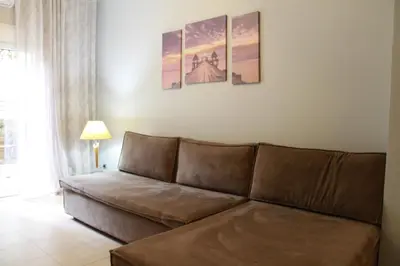 a living room with a brown couch in a room at Apartment Maxim in Athens