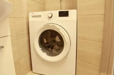 a washing machine in a bathroom with a wall at Apartment Maxim in Athens