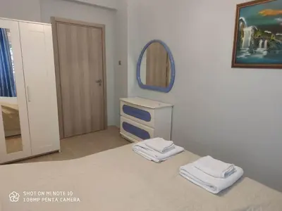 a room with a tv and a mirror and towels at Apartment Maxim in Athens