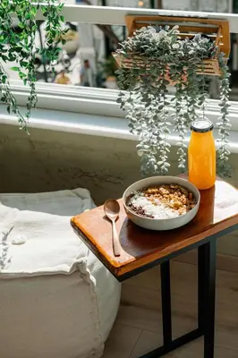 a bowl of cereal on a table next to a window at Eunoia Suite - Monastiraki Square View in Athens