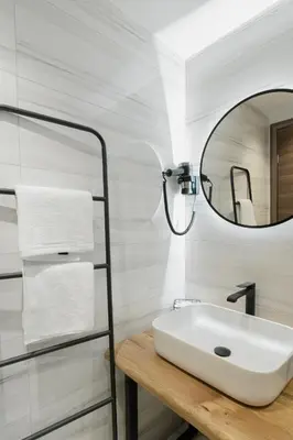 a white bathroom with a sink and a mirror at Eunoia Suite - Monastiraki Square View in Athens